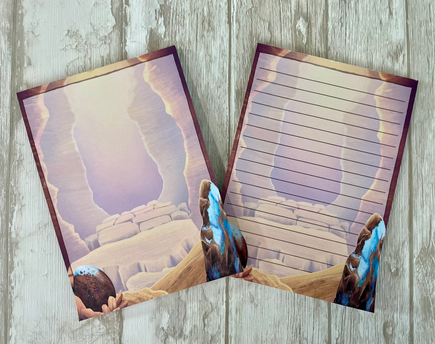 Two 5 by 7 inch notepads with 50 pages that each feature the mesa canyon that is the background from the art print.  Each page background show off the opal dragon egg in the left bottom hand corner and a large raw opal mineral rock on the bottom right hand corner.  One design is blank and the other has lines to write on.