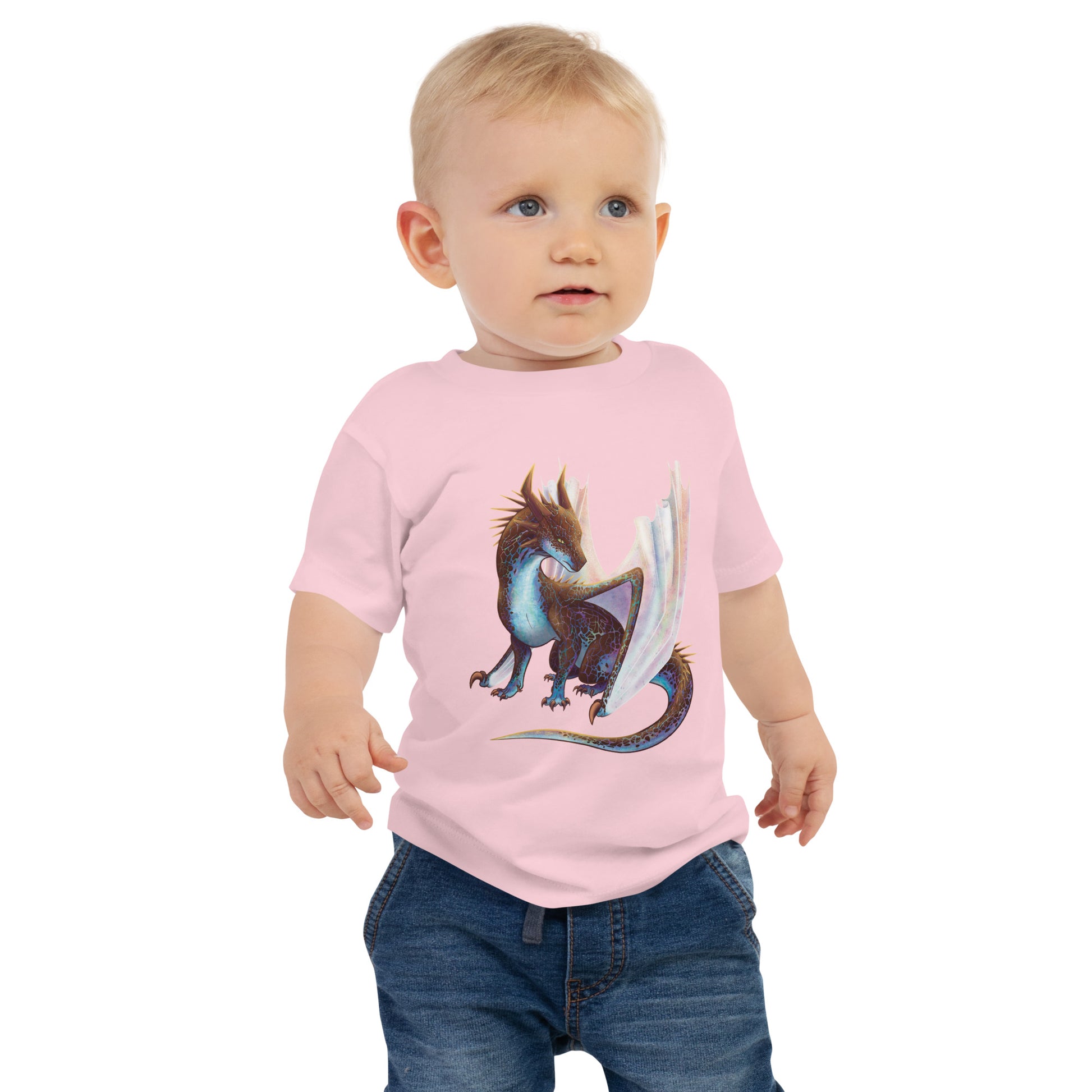 Unisex, pink in color baby tee shirt featuring a sitting, side profile of a dragon that has the features of a boulder opal with hues of blue, green, purple, and pink on the underbelly and cracks of the rough, brown hue, rock scales. The wings are tucked back and are of an iridescent shimmery hue