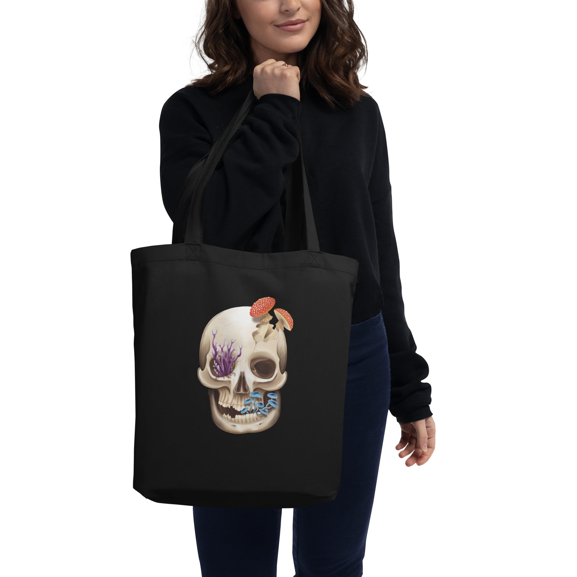 A black tote bag made of 100% cotton twill material that features a human skull with various fungi growing out of it