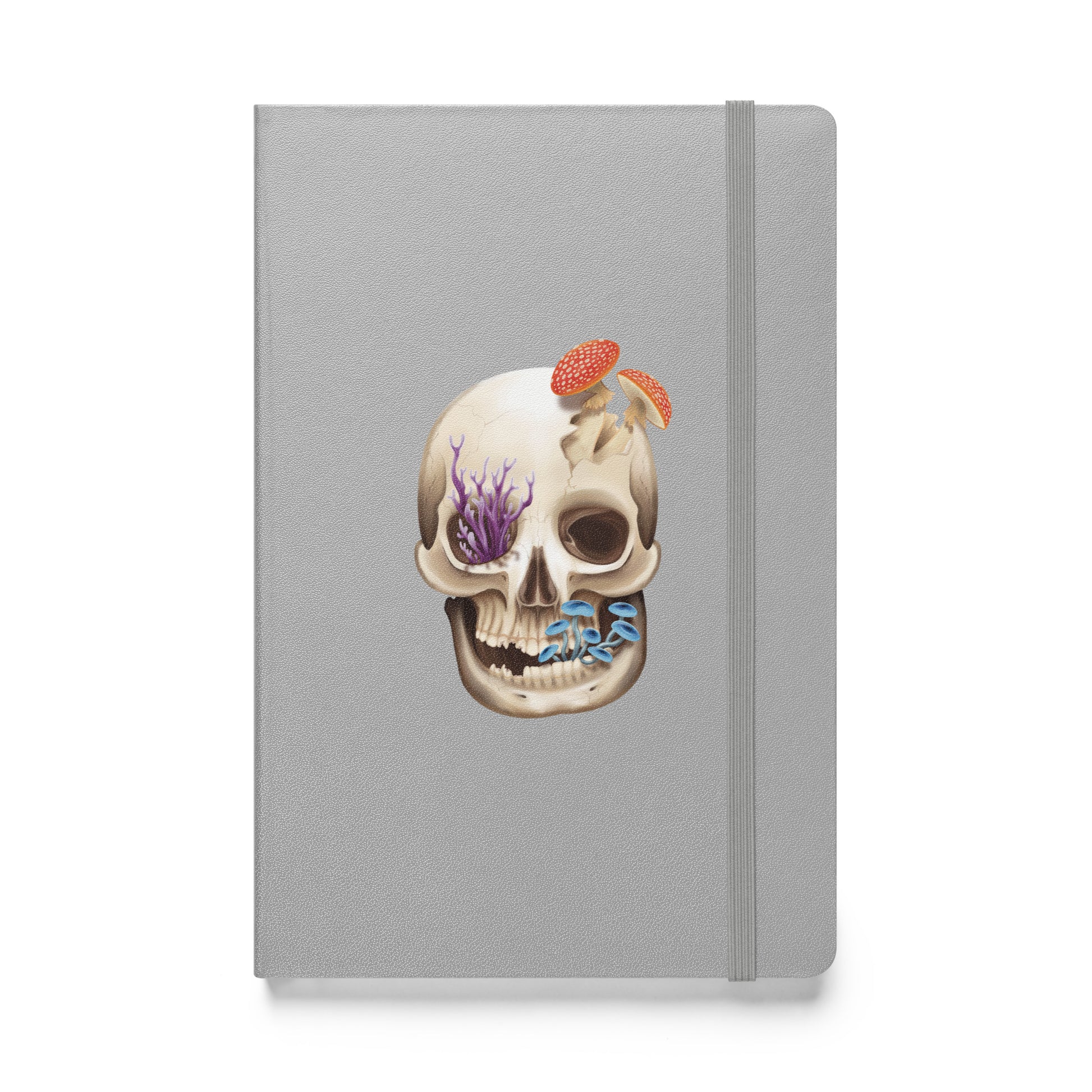 A silver notebook with an elastic closure, 80 lined pages, a ribbon bookmark, and pocket in the back that features a human skull with various fungi growing out of it on the front cover