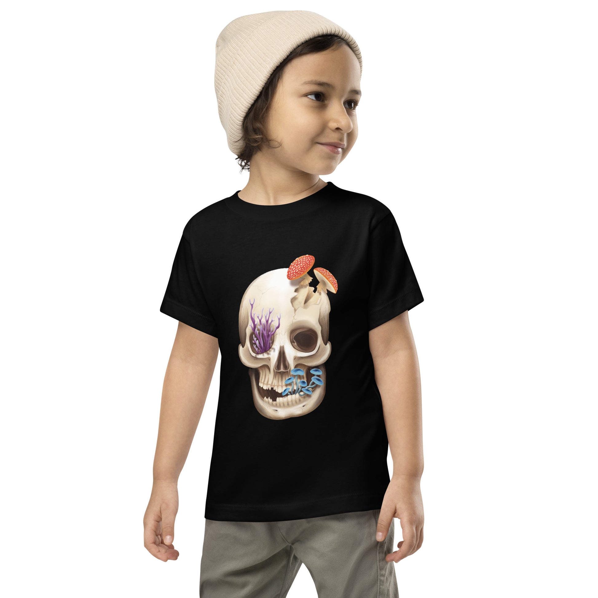 A black t shirt for a toddler featuring a front facing human skull with 3 different kinds of fungi growing out of it