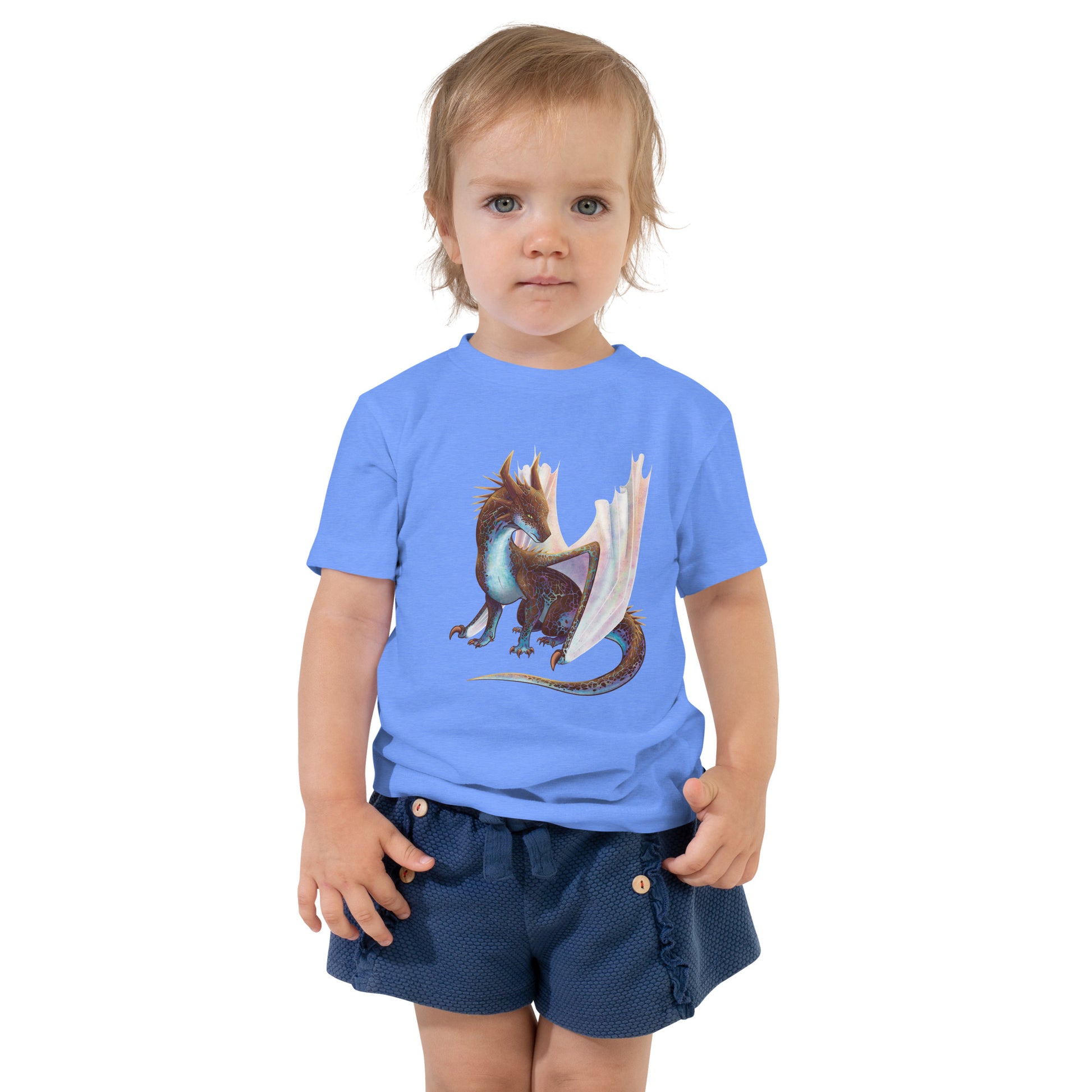 Unisex, light blue in color toddler tee shirt featuring a sitting, side profile of a dragon that has the features of a boulder opal with hues of blue, green, purple, and pink on the underbelly and cracks of the rough, brown hue, rock scales. The wings are tucked back and are of an iridescent shimmery hue