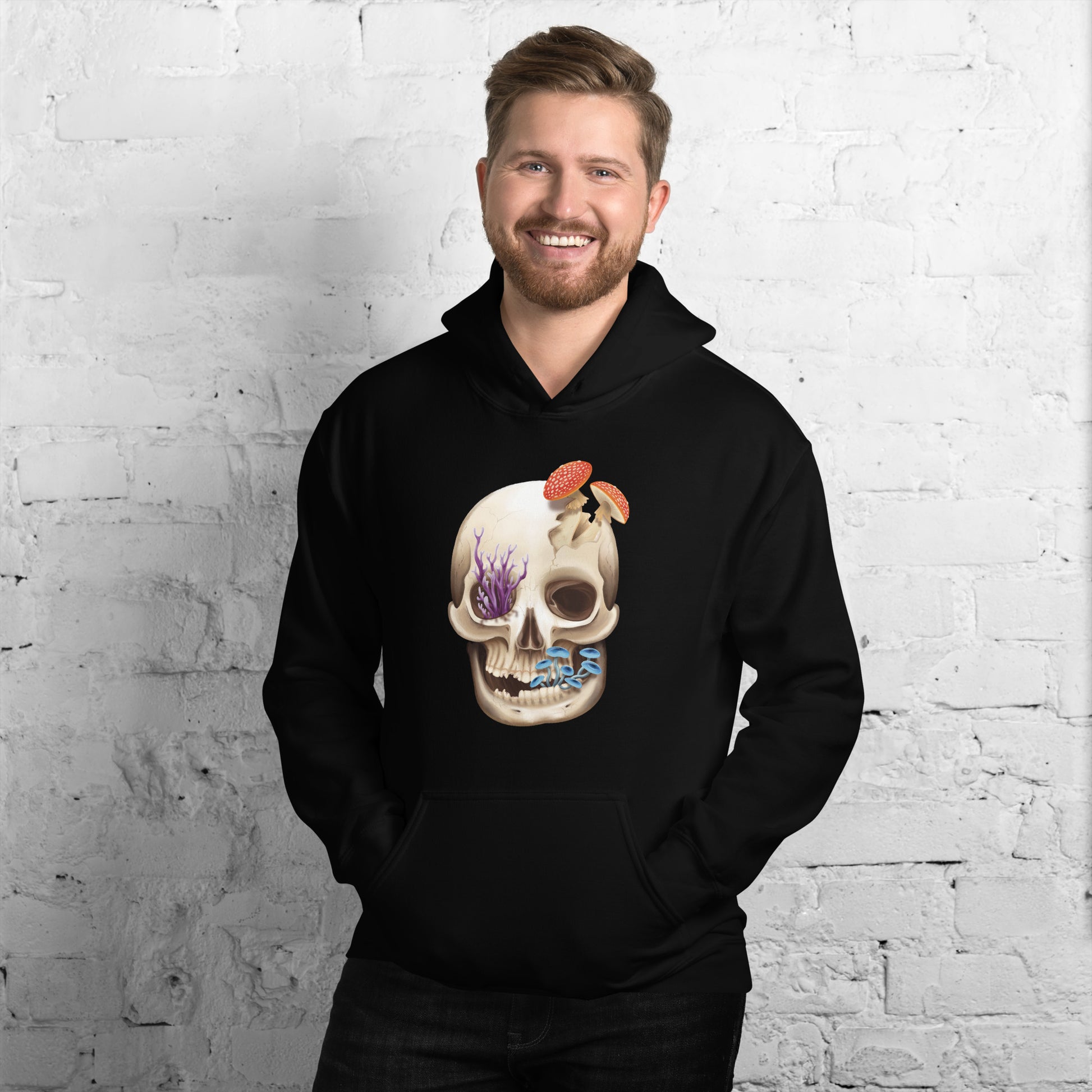 A black adult hoodie with a front hand pocket featuring a front facing human skull with 3 different kinds of fungi growing out of it