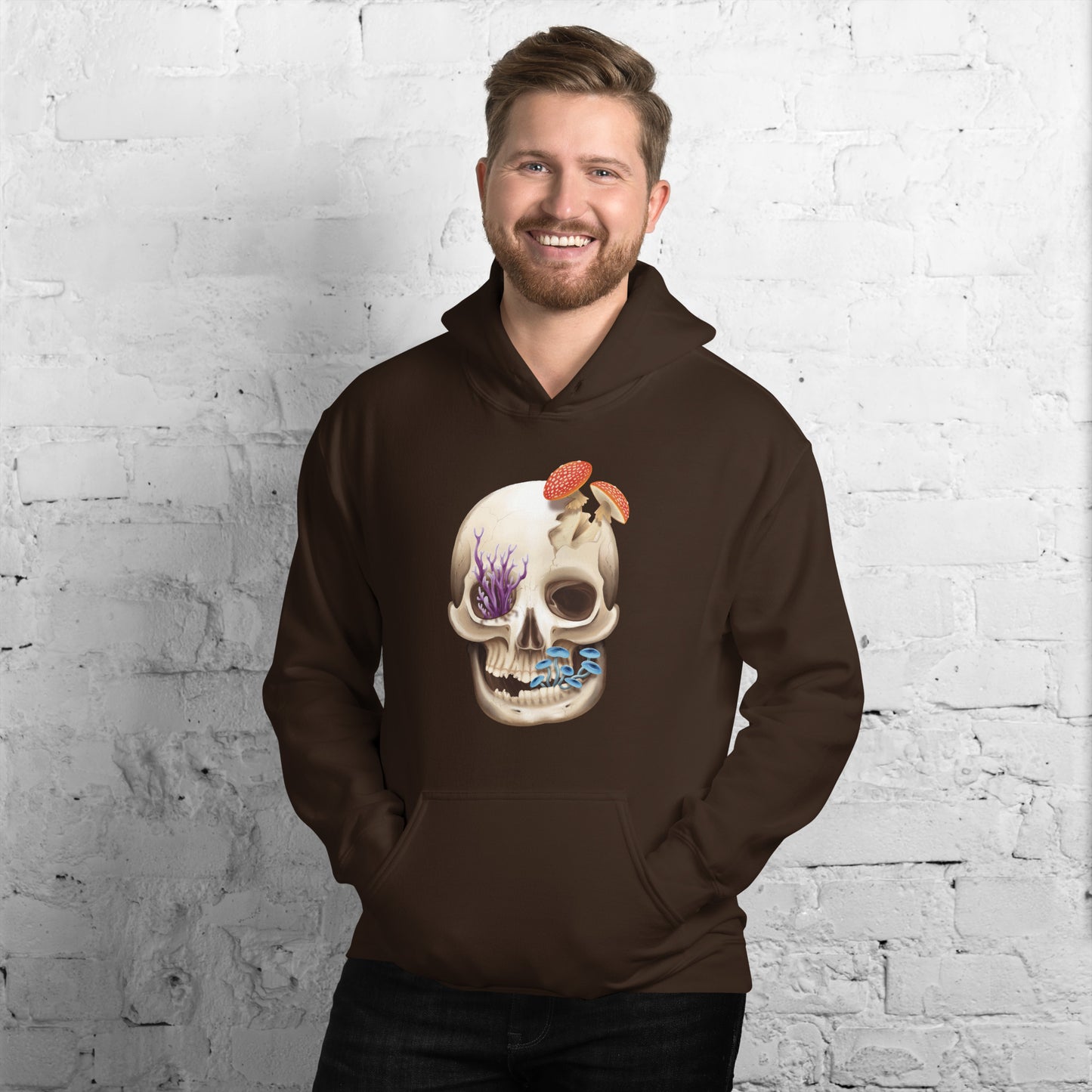 A chocolate brown adult hoodie with a front hand pocket featuring a front facing human skull with 3 different kinds of fungi growing out of it