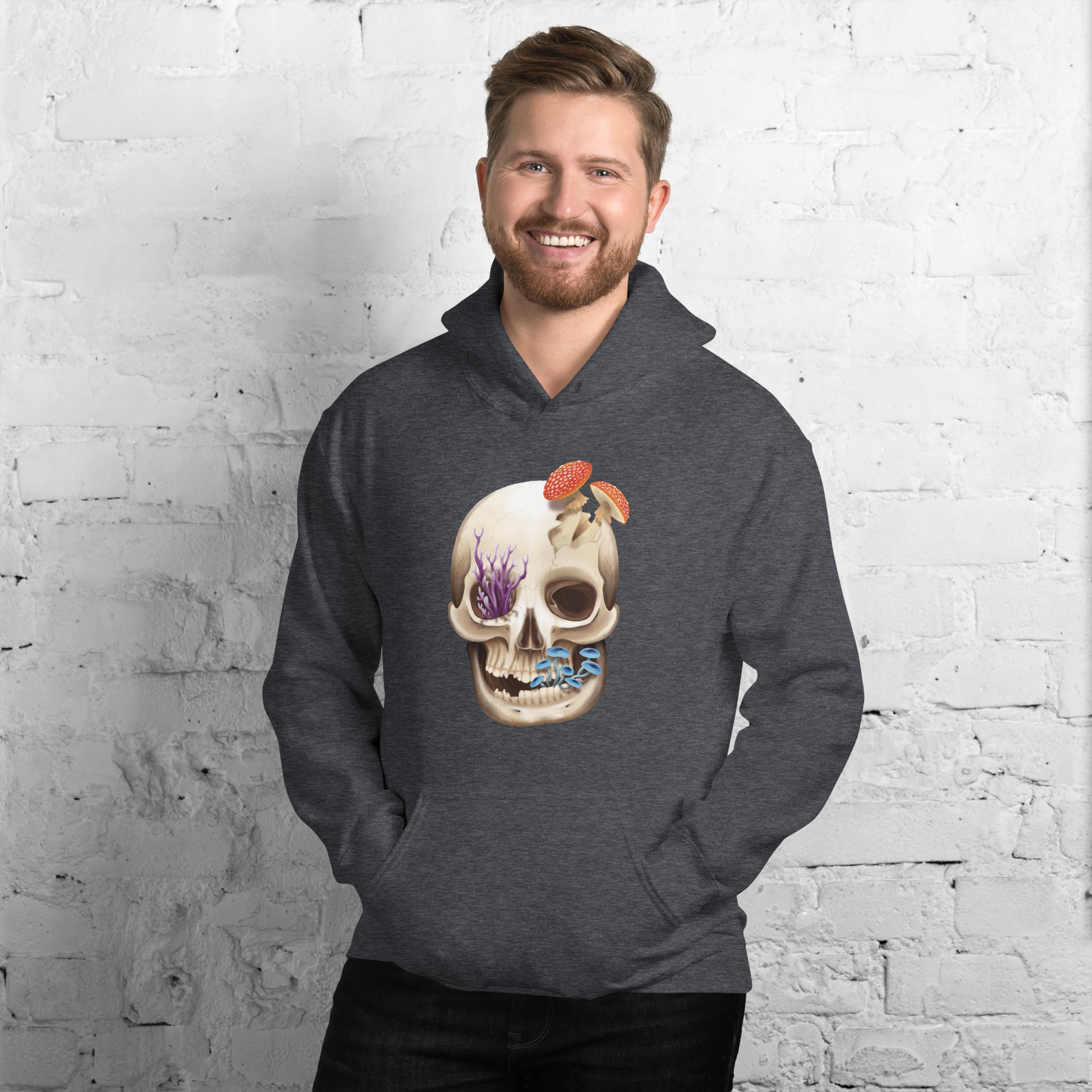 A dark heather grey adult hoodie with a front hand pocket featuring a front facing human skull with 3 different kinds of fungi growing out of it