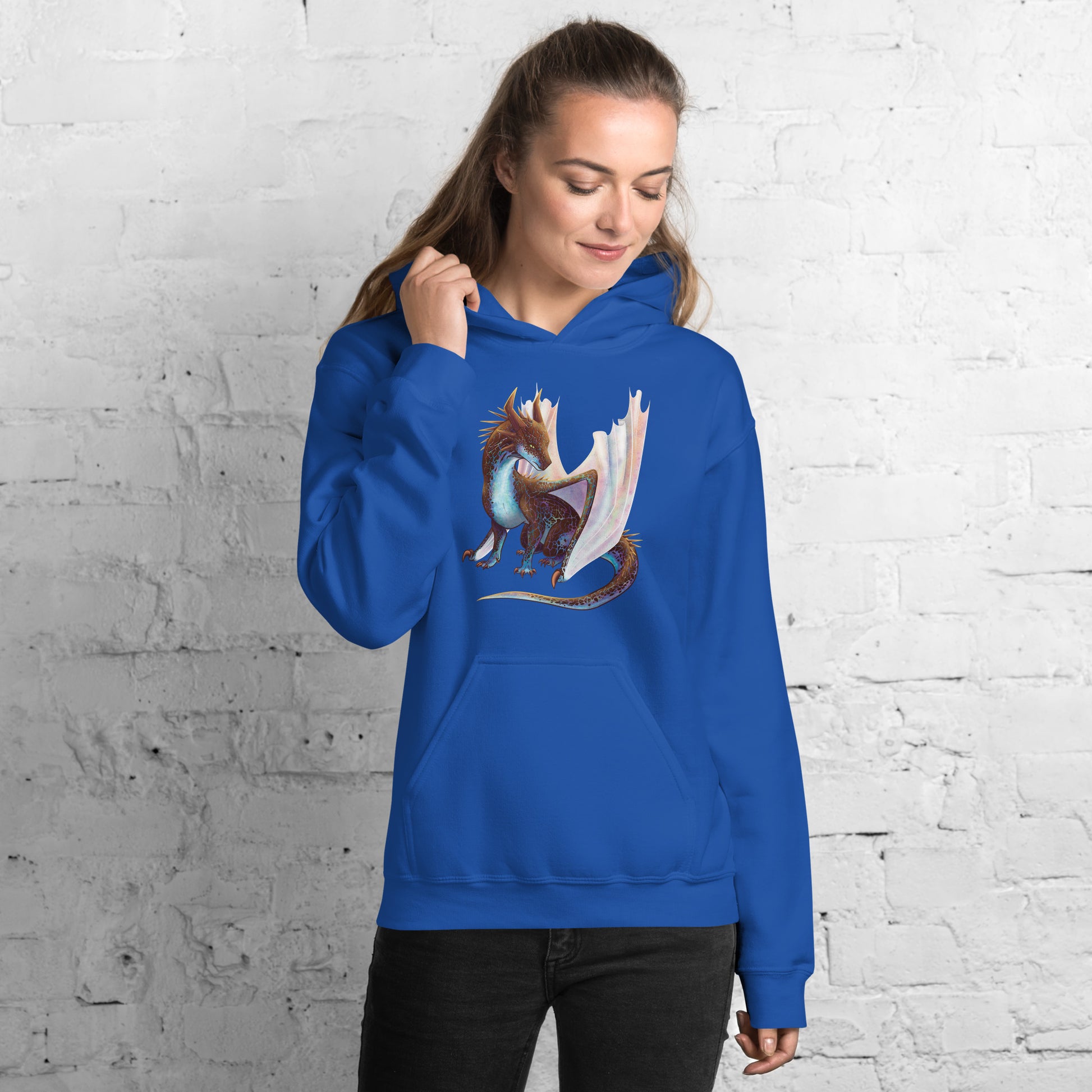 Unisex, royal blue in color adult hoodie with a pocket in front featuring a sitting, side profile of a dragon that has the features of a boulder opal with hues of blue, green, purple, and pink on the underbelly and cracks of the rough, brown hue, rock scales. The wings are tucked back and are of an iridescent shimmery hue