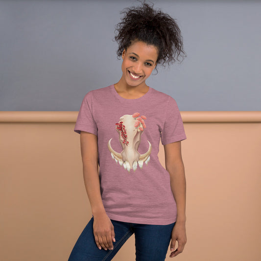 An adult wearing a heather orchid colored, unisex T shirt featuring a front facing warthog skull with 3 different kinds of fungi growing out of it