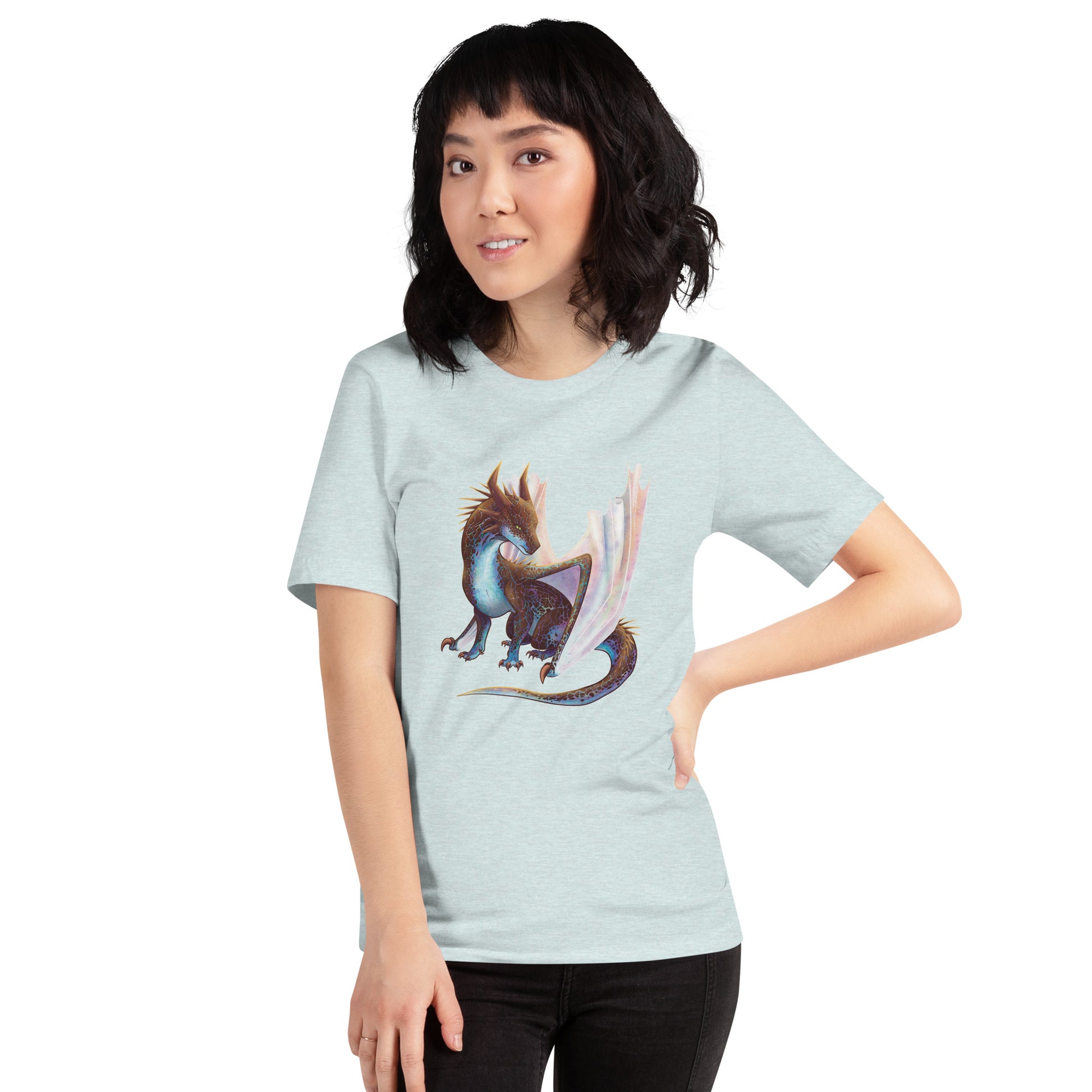 Unisex, heather ice blue in color adult short sleeve tee shirt featuring a sitting, side profile of a dragon that has the features of a boulder opal with hues of blue, green, purple, and pink on the underbelly and cracks of the rough, brown hue, rock scales. The wings are tucked back and are of an iridescent shimmery hue