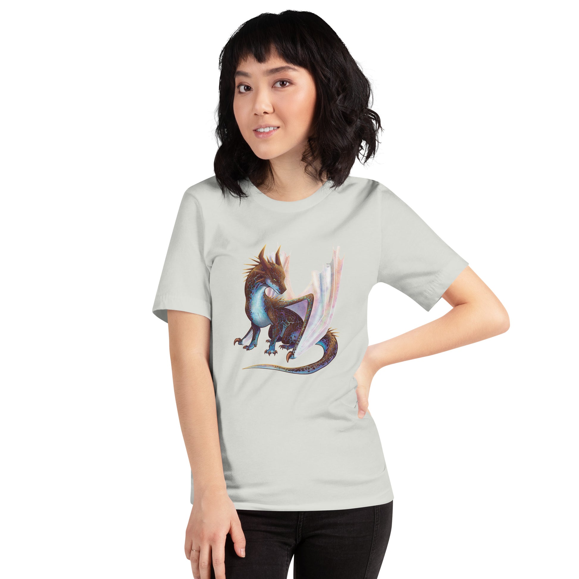 Unisex, light silver in color adult short sleeve tee shirt featuring a sitting, side profile of a dragon that has the features of a boulder opal with hues of blue, green, purple, and pink on the underbelly and cracks of the rough, brown hue, rock scales. The wings are tucked back and are of an iridescent shimmery hue