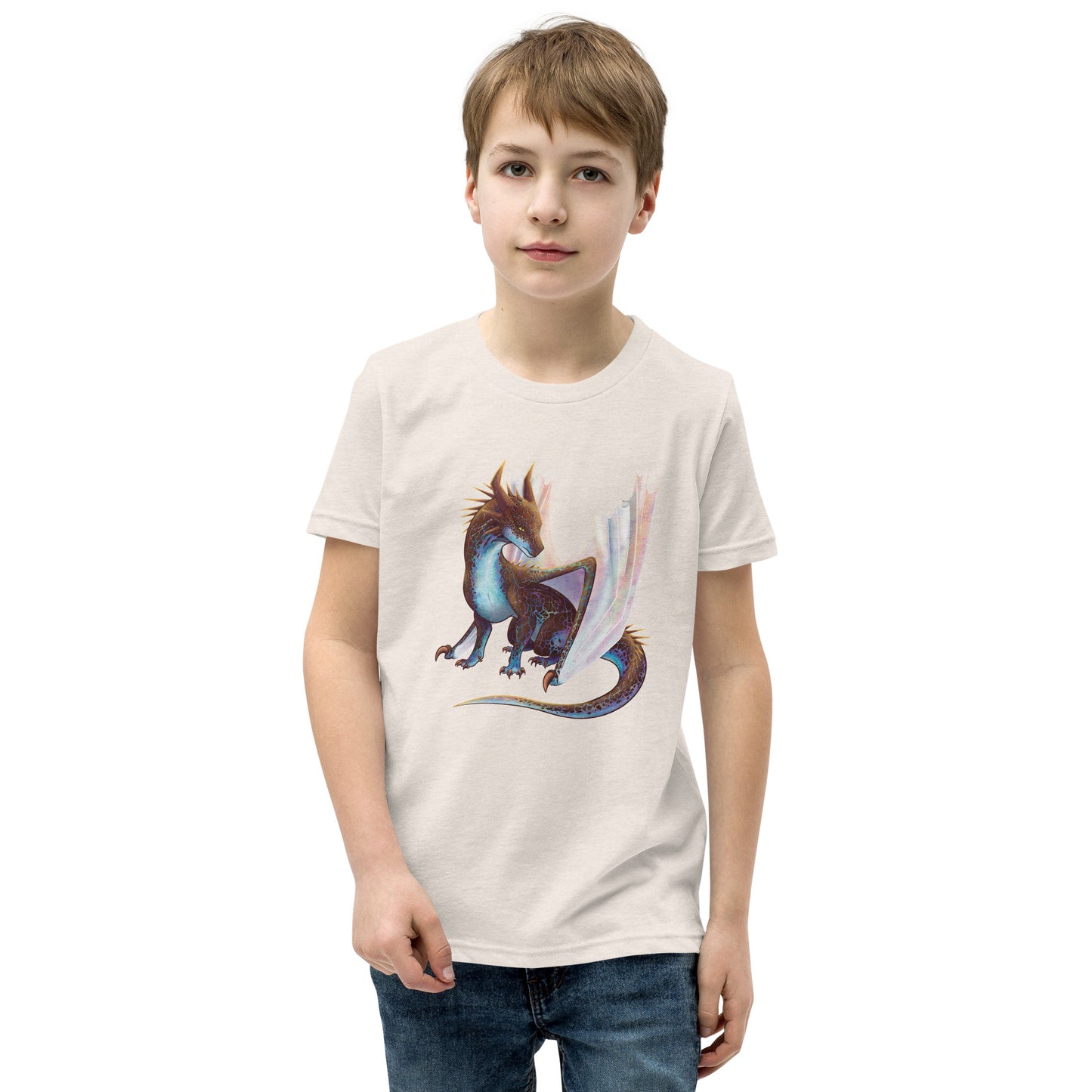 Unisex, heather dust in color youth short sleeve tee shirt featuring a sitting, side profile of a dragon that has the features of a boulder opal with hues of blue, green, purple, and pink on the underbelly and cracks of the rough, brown hue, rock scales. The wings are tucked back and are of an iridescent shimmery hue